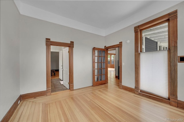 spare room with baseboards and wood finished floors