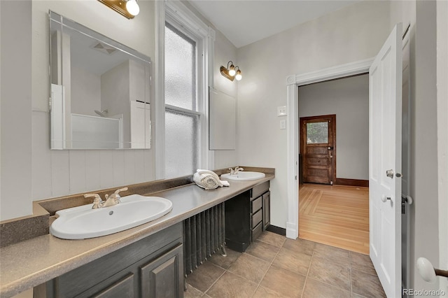 full bathroom featuring double vanity, plenty of natural light, and a sink