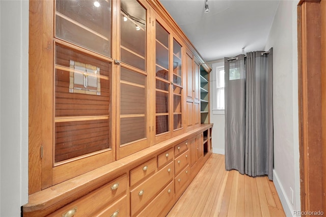 hallway with light wood-style flooring and baseboards