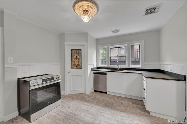 kitchen with dark countertops, visible vents, appliances with stainless steel finishes, and a sink