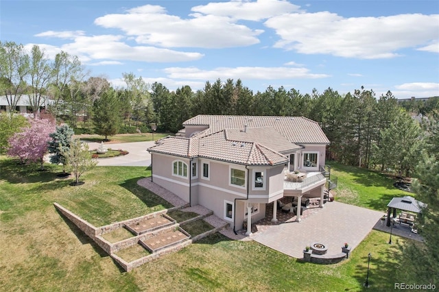 back of property with a gazebo, stucco siding, a patio area, a tiled roof, and a yard