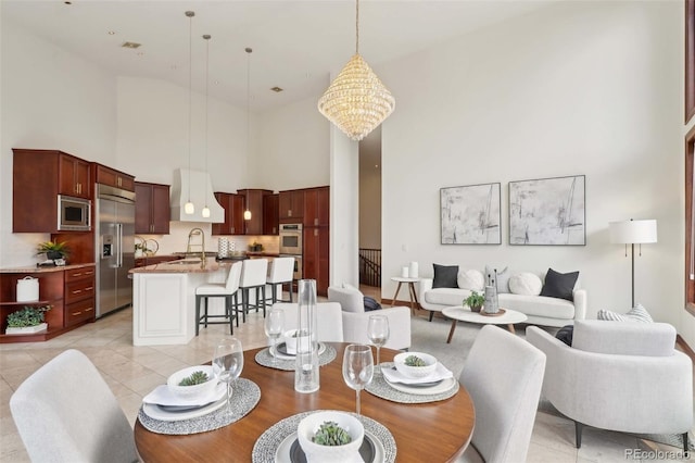 dining room featuring a towering ceiling and light tile patterned floors