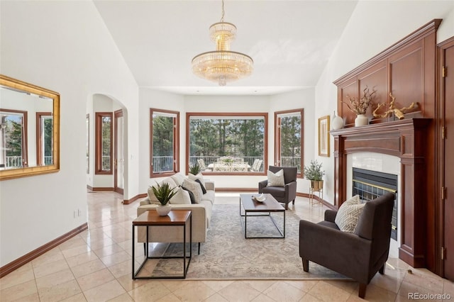 living room with arched walkways, baseboards, vaulted ceiling, and light tile patterned floors
