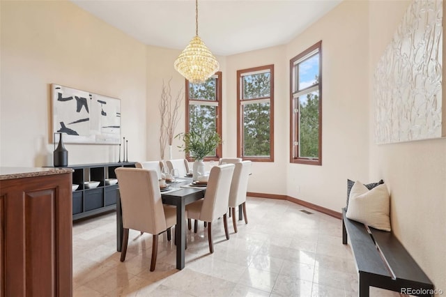 dining room with baseboards and a chandelier
