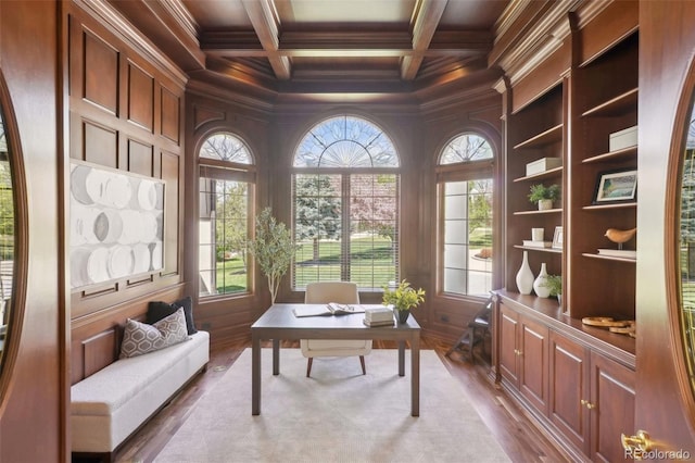 office space with beamed ceiling, plenty of natural light, ornamental molding, and wood finished floors