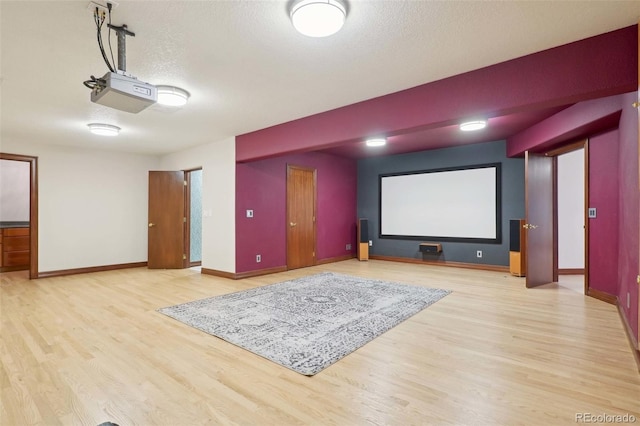 home theater with a textured ceiling, baseboards, and wood finished floors