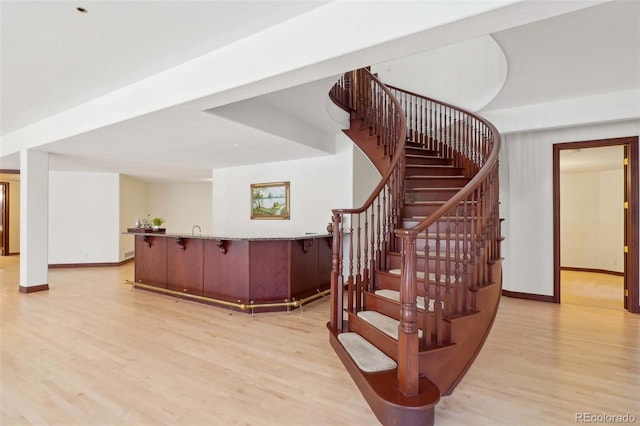 staircase with baseboards and wood finished floors