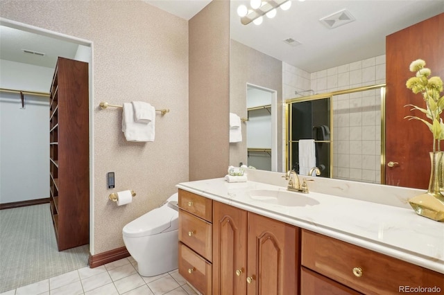 full bathroom with a walk in closet, vanity, toilet, a shower stall, and visible vents