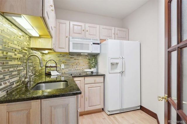 kitchen with light wood-style floors, a sink, white appliances, and tasteful backsplash
