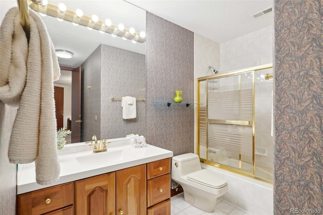 bathroom with visible vents, vanity, toilet, tiled shower / bath, and tile patterned floors