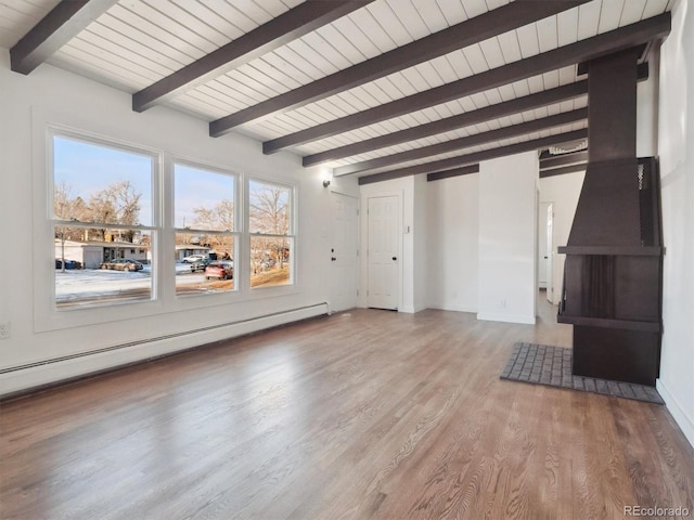 unfurnished living room featuring baseboard heating, beam ceiling, and wood-type flooring