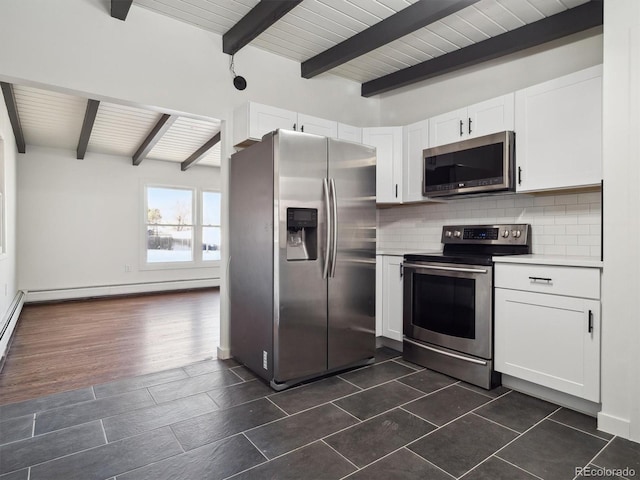 kitchen featuring baseboard heating, appliances with stainless steel finishes, beamed ceiling, decorative backsplash, and white cabinets