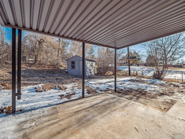 snow covered patio with a shed