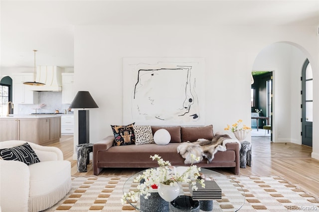 living room with light wood-style floors and arched walkways