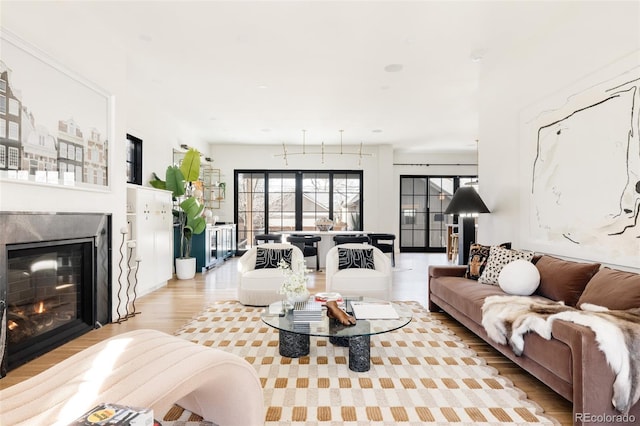 living room with light wood finished floors and a glass covered fireplace