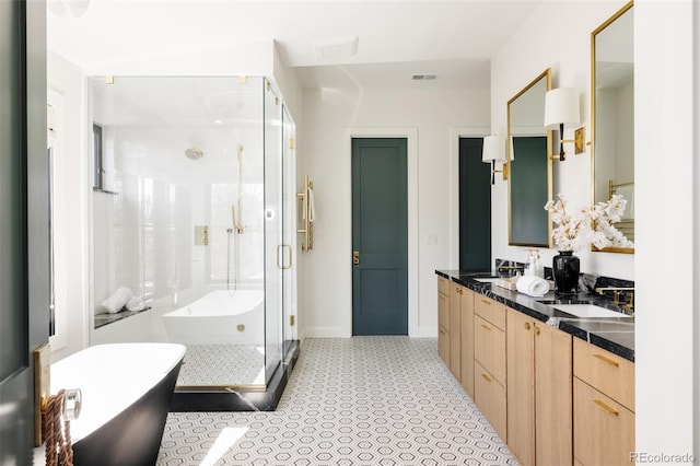 bathroom with double vanity, visible vents, a freestanding tub, a shower stall, and a sink