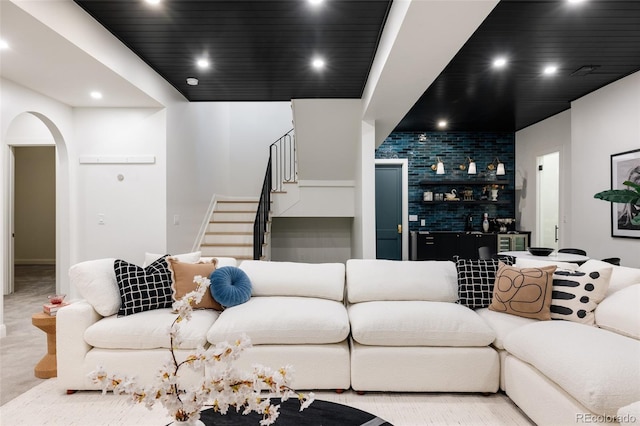 living room featuring carpet floors, arched walkways, recessed lighting, and stairs