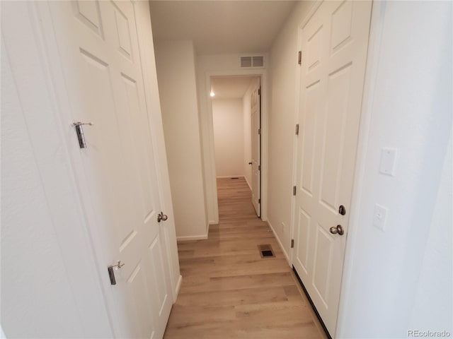 corridor with light hardwood / wood-style floors