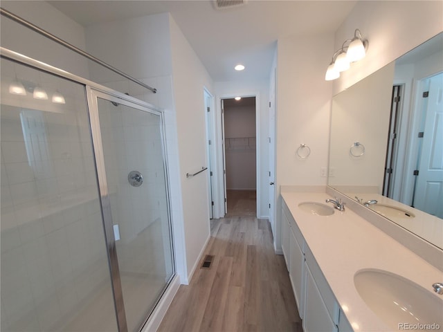 bathroom featuring hardwood / wood-style floors, an enclosed shower, and vanity