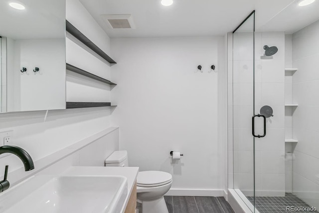 full bath featuring a stall shower, toilet, and wood finished floors