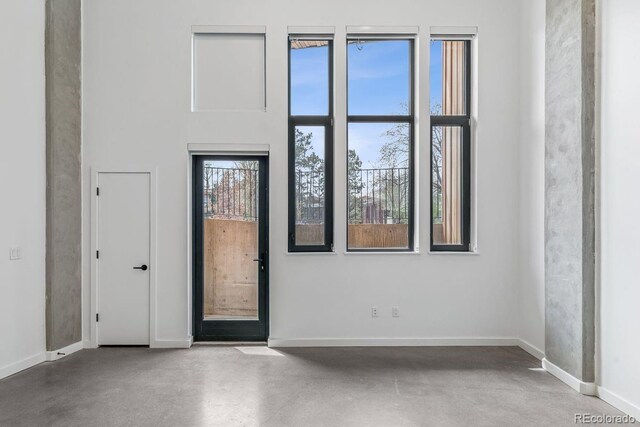 interior space with baseboards and finished concrete flooring
