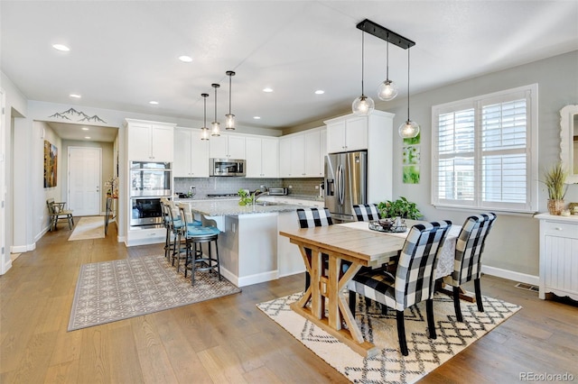 dining room featuring sink and light hardwood / wood-style floors