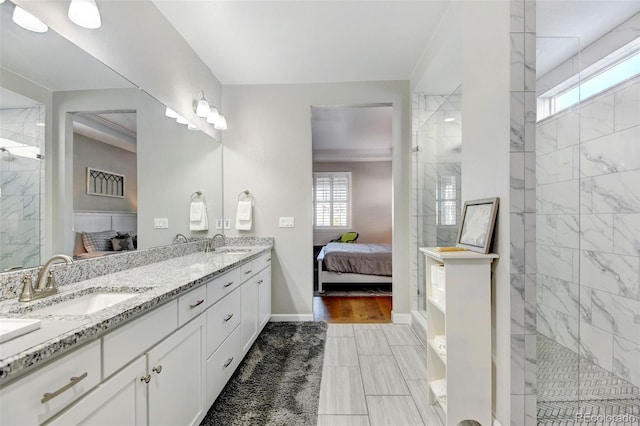 bathroom featuring tiled shower, wood-type flooring, and vanity