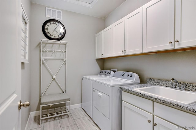 laundry area featuring sink, cabinets, and separate washer and dryer