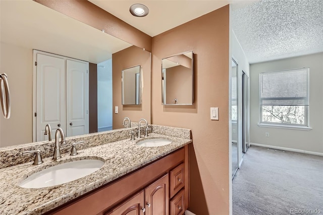 bathroom with baseboards and double vanity