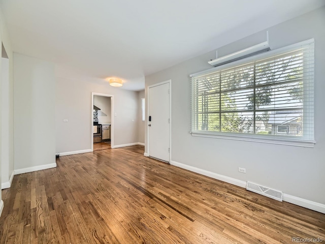 835 Knox Ct, Denver, CO 80204 - unfurnished living room with baseboards, visible vents, and wood finished floors