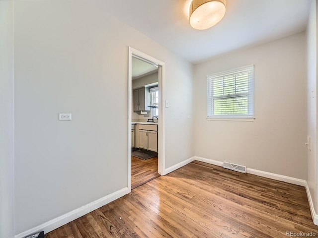 835 Knox Ct, Denver, CO 80204 - unfurnished room with baseboards, light wood finished floors, and visible vents