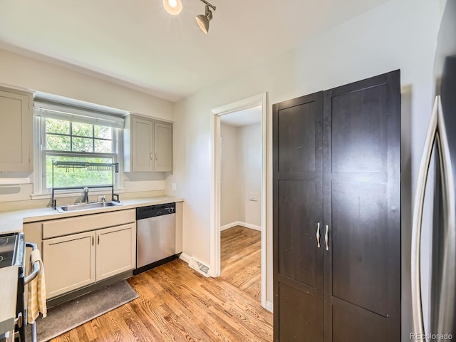 835 Knox Ct, Denver, CO 80204 - kitchen featuring stainless steel dishwasher, a sink, light countertops, light wood-type flooring, and electric range