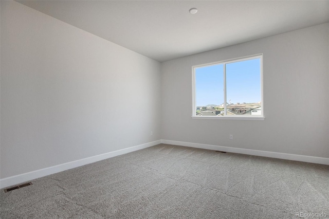 empty room featuring light carpet, baseboards, and visible vents