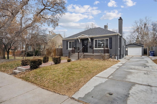 bungalow with a garage, an outdoor structure, and a front lawn