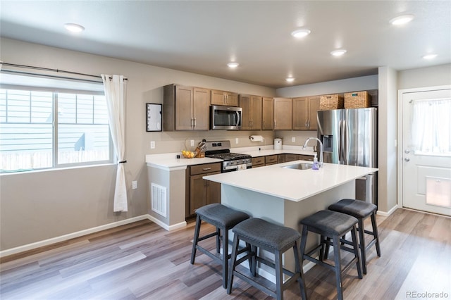 12743 Ulster St, Thornton, CO 80602 - kitchen featuring a breakfast bar, stainless steel appliances, healthy amount of natural light, light wood-style floors, and recessed lighting