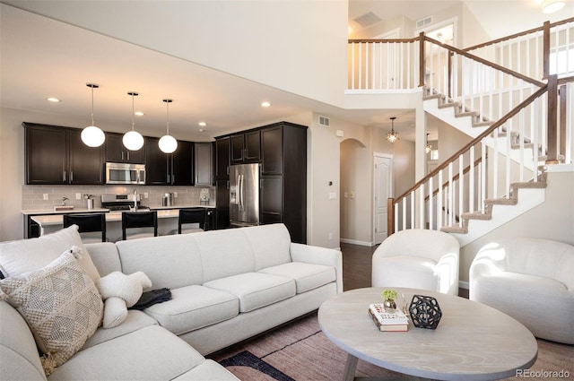 2559 S Kendrick St, Lakewood, CO 80228 - living room featuring recessed lighting, arched walkways, baseboards, and stairs