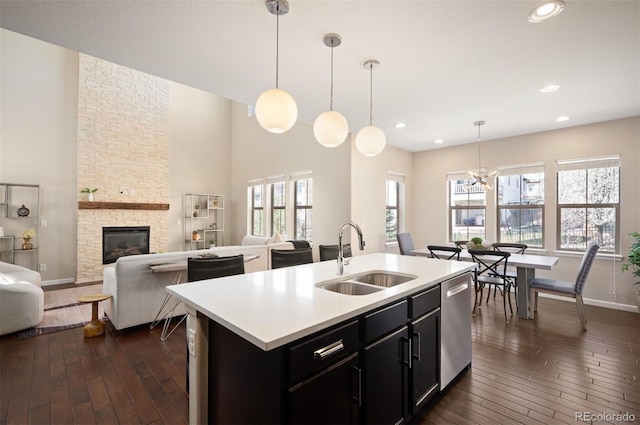 2559 S Kendrick St, Lakewood, CO 80228 - kitchen with stainless steel dishwasher, a sink, dark wood-type flooring, and light countertops
