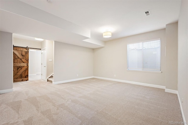 2559 S Kendrick St, Lakewood, CO 80228 - below grade area with visible vents, a barn door, stairway, baseboards, and carpet