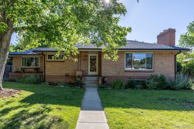 6273 S Prescott St, Littleton, CO 80120 - view of front of house with a chimney, a front yard, and brick siding