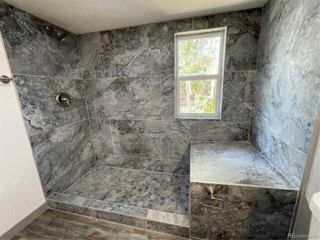 bathroom featuring a tile shower and toilet