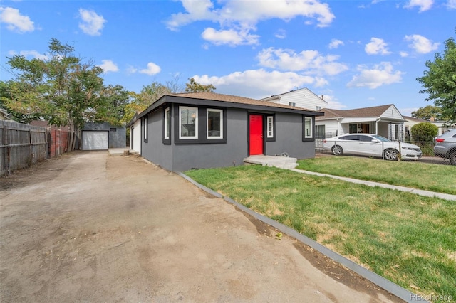 view of front of property featuring a garage, an outdoor structure, and a front yard