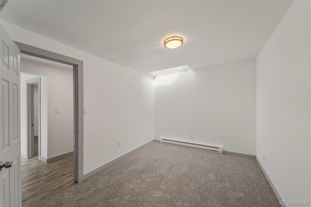 carpeted spare room with a baseboard radiator