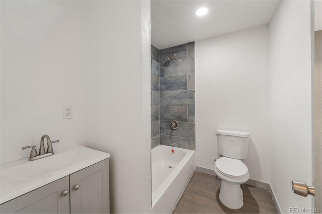 full bathroom featuring vanity, toilet, tiled shower / bath combo, and wood-type flooring