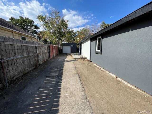 view of side of home featuring a garage and an outbuilding