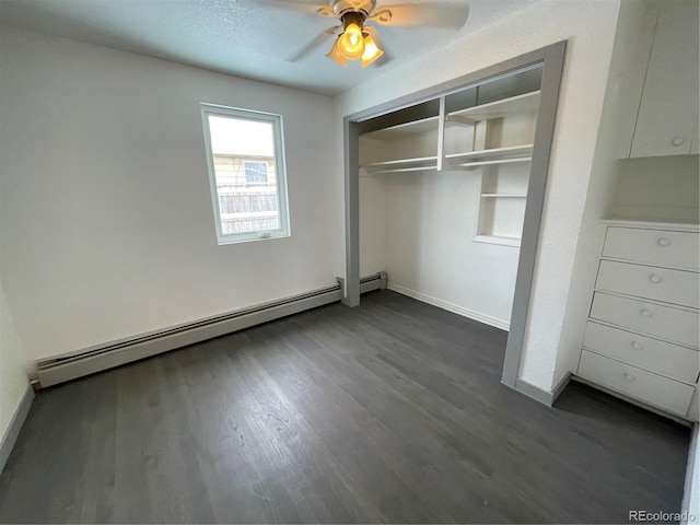 unfurnished bedroom featuring ceiling fan, a baseboard heating unit, dark hardwood / wood-style floors, a textured ceiling, and a closet