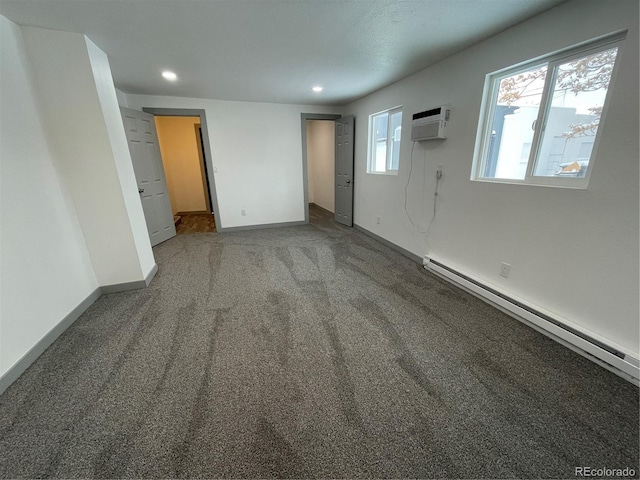 empty room featuring carpet floors, a wall mounted AC, and baseboard heating