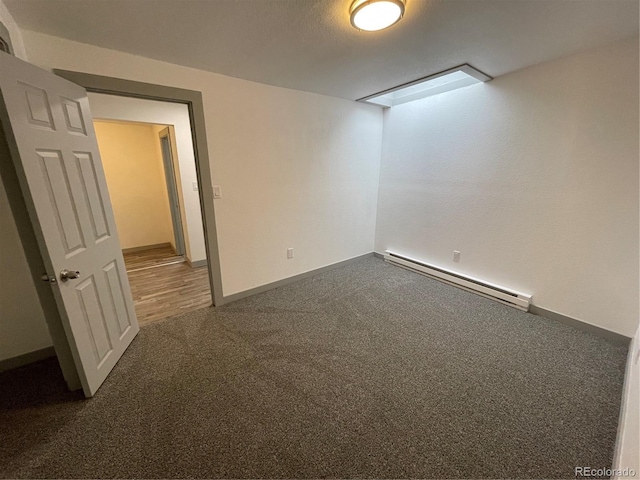 empty room with carpet floors and a baseboard radiator