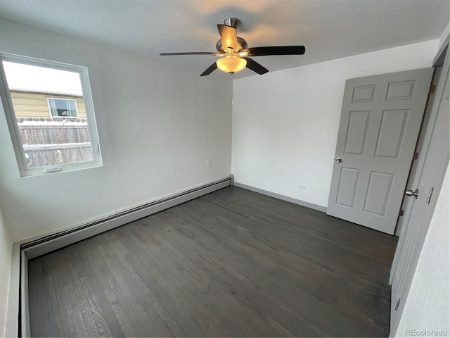 empty room with a baseboard heating unit, dark wood-type flooring, and ceiling fan