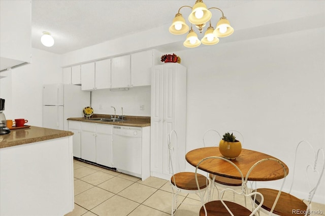 10211 Ura Ln Unit 101, Thornton, CO 80260 - kitchen with white appliances, dark countertops, light tile patterned floors, a chandelier, and white cabinetry