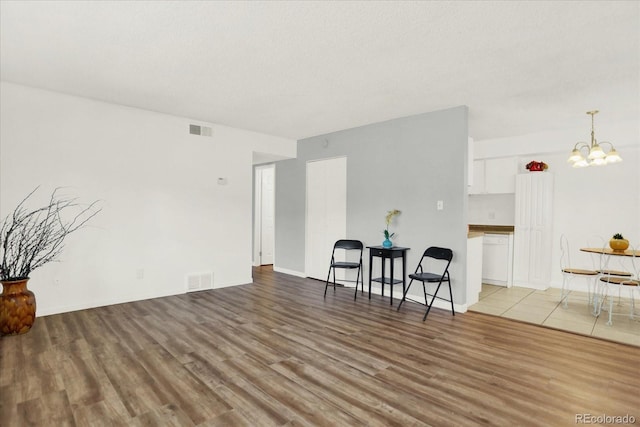 10211 Ura Ln Unit 101, Thornton, CO 80260 - living room featuring a chandelier and light wood-type flooring